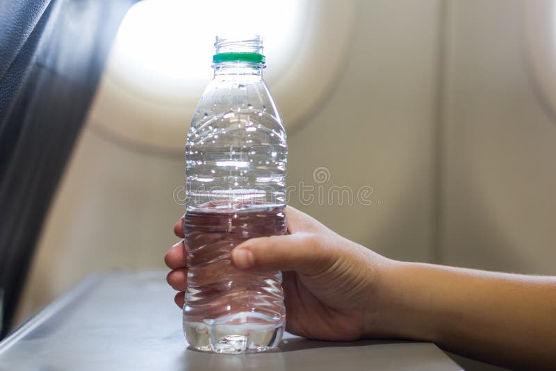 A Passenger Woman on a Airplane Flight Drinking a Bottle of Water Stock  Image - Image of hand, body: 184264045