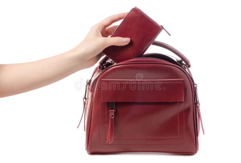 Female hand holding red purse and red bag