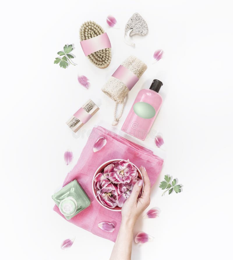 Female hand holding water bowl with pink flowers on white desktop with various eco friendly spa and skin care tools and cosmetic stock image Female hand holding water bowl with pink flowers on white desktop with various eco friendly spa and skin care tools and cosmetic stock image