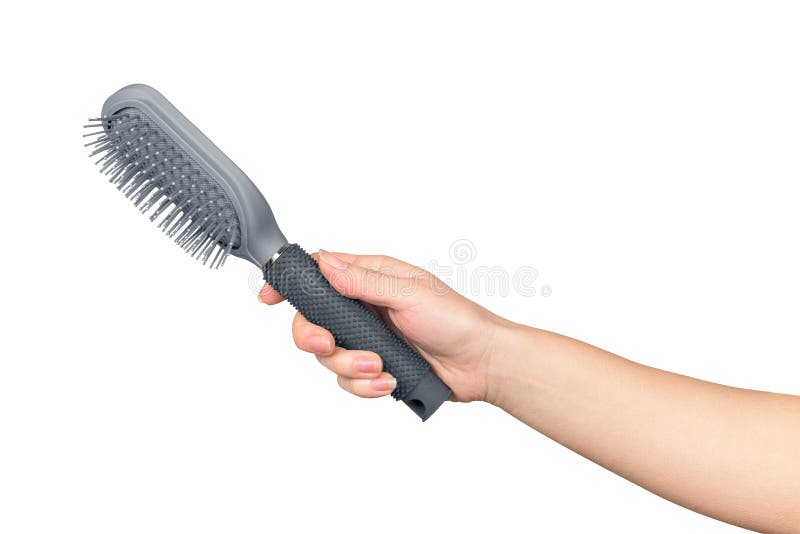 A female hand holds the comb brush stock image