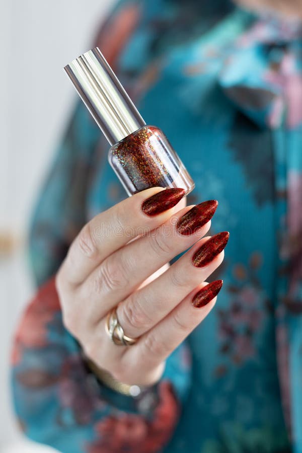 Female Hand with Long Nails and Golden Maroon, Manicure Holds a Bottle of Nail Polish Stock Photo - Image of feminine, bronze: 219527726 Female Hand with Long Nails and Golden Maroon, Manicure Holds a Bottle of Nail Polish Stock Photo - Image of feminine, bronze: 219527726