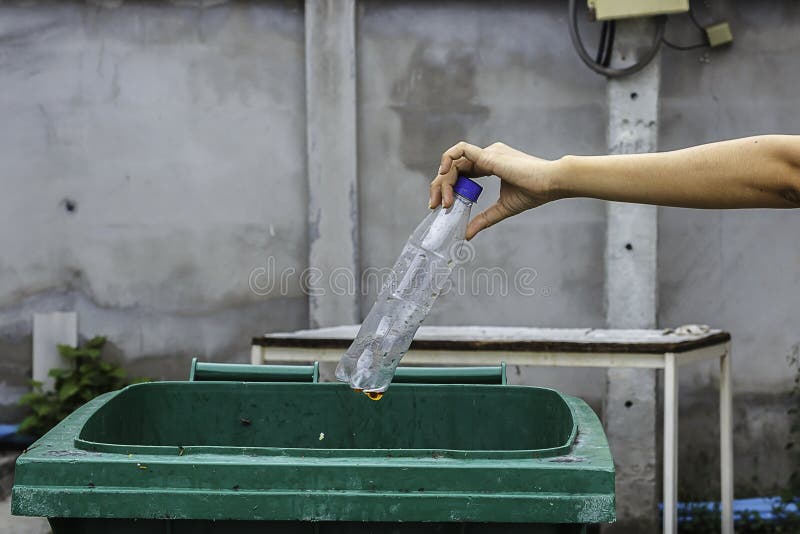 Female Hand Throwing Empty Plastic Bottle into the Trash. Stock Image