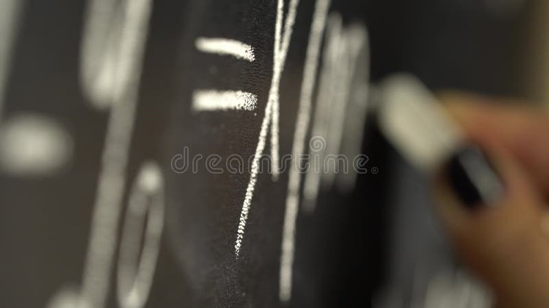 Hand writing with chalk the algebra formula on the blackboard. Close up stock video footage