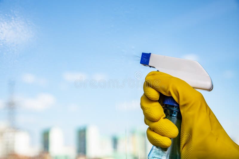 Female hand in yellow gloves cleaning window with spray detergent. Spring cleanup stock photo Female hand in yellow gloves cleaning window with spray detergent. Spring cleanup stock photo