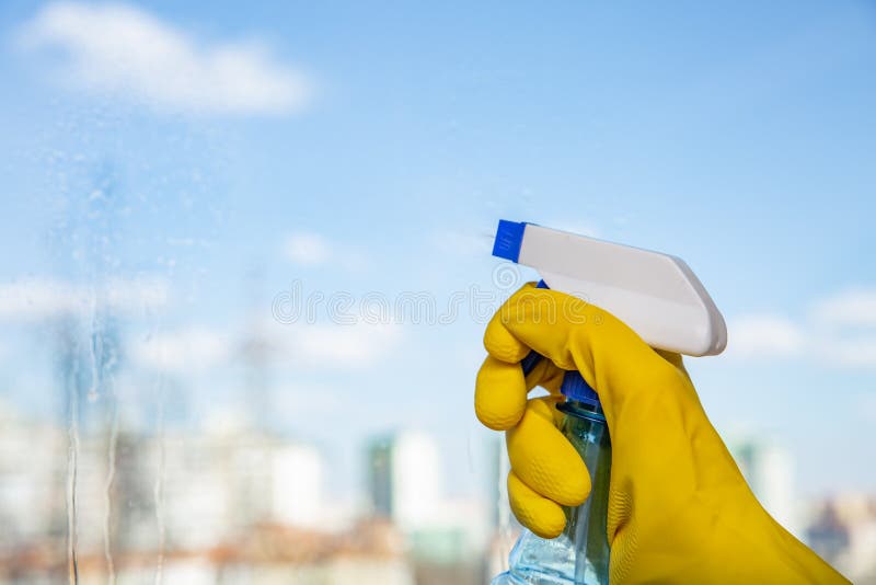 Female hand in yellow gloves cleaning window with spray detergent. Spring cleanup stock photography Female hand in yellow gloves cleaning window with spray detergent. Spring cleanup stock photography