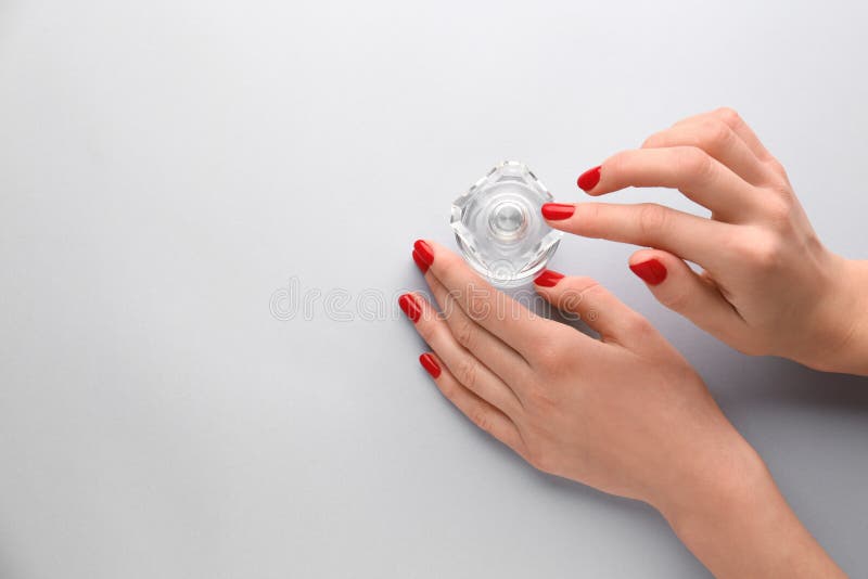 Female hands with bottle of perfume on light background royalty free stock photo