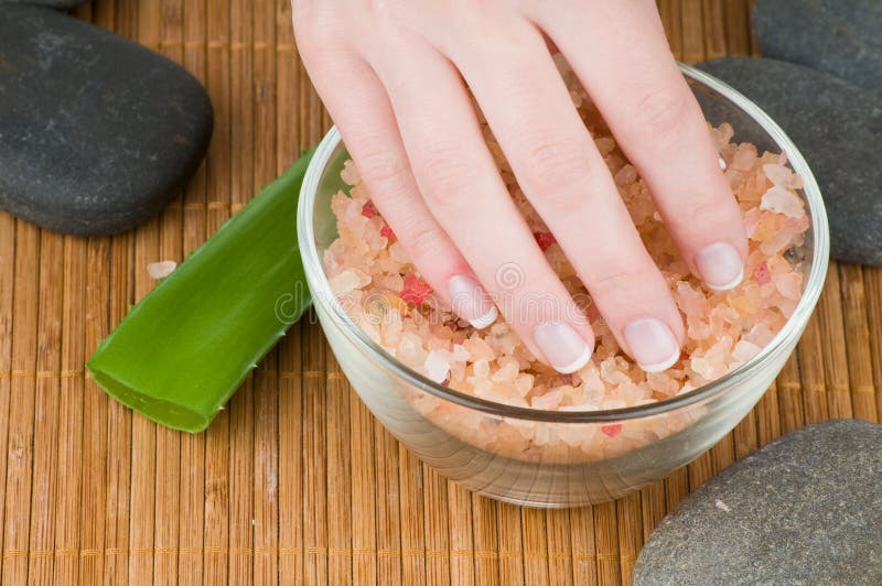 Female hands with french manicure and sea salt