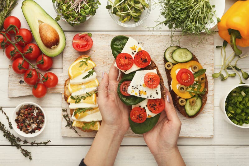 Woman making tasty bruschettas for healthy snack, top view