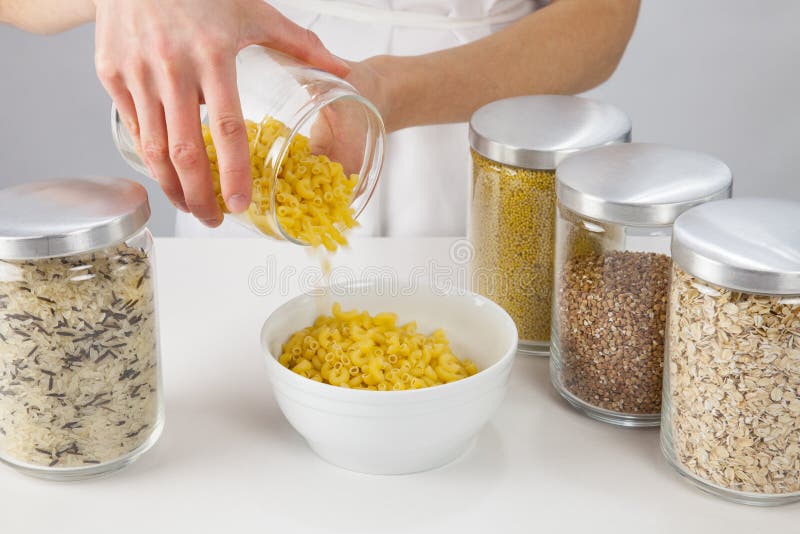 Female hands holding a pot with raw macaroni