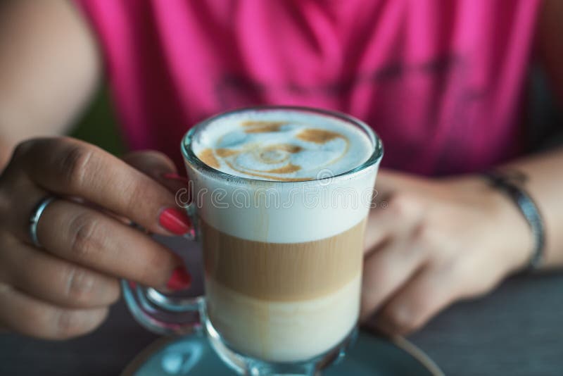 Female hands with latte coffee in cafe, close up stock photos Female hands with latte coffee in cafe, close up stock photos