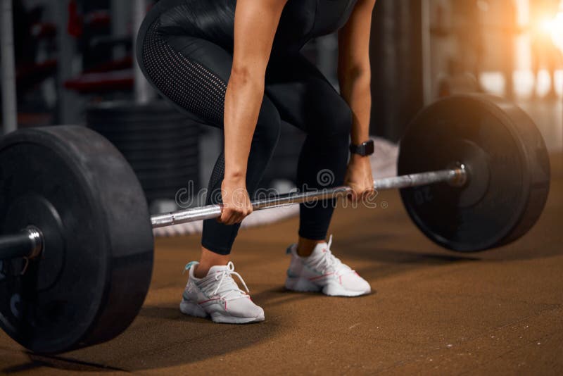 Female hands lifting barbell from floor stock image Female hands lifting barbell from floor stock image