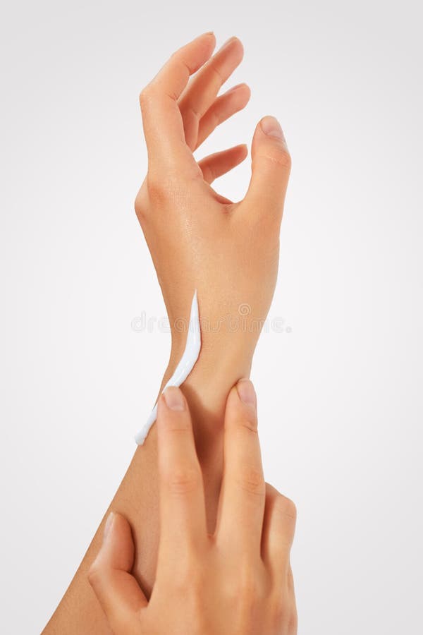 Female hands with a moisturiser on light background. Close-up of Woman Applying Cream on Hand. Hands Skin Care
