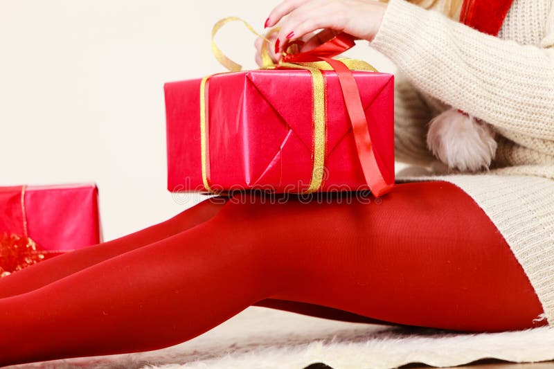 Woman opening or wrapping red box gift.