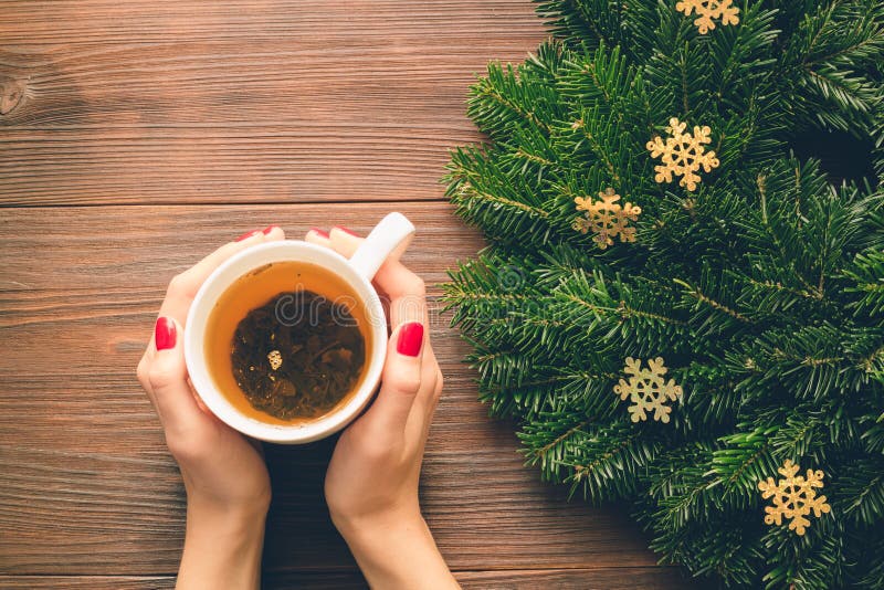 Female hands with red manicure holding a cup of tea on a background of Christmas decorations royalty free stock photos Female hands with red manicure holding a cup of tea on a background of Christmas decorations royalty free stock photos