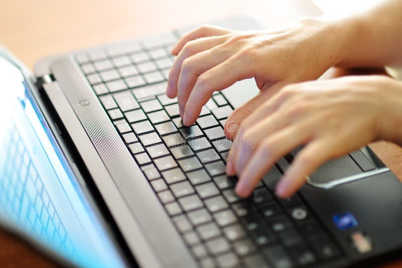 Female hands typing on a laptop pc keyboard
