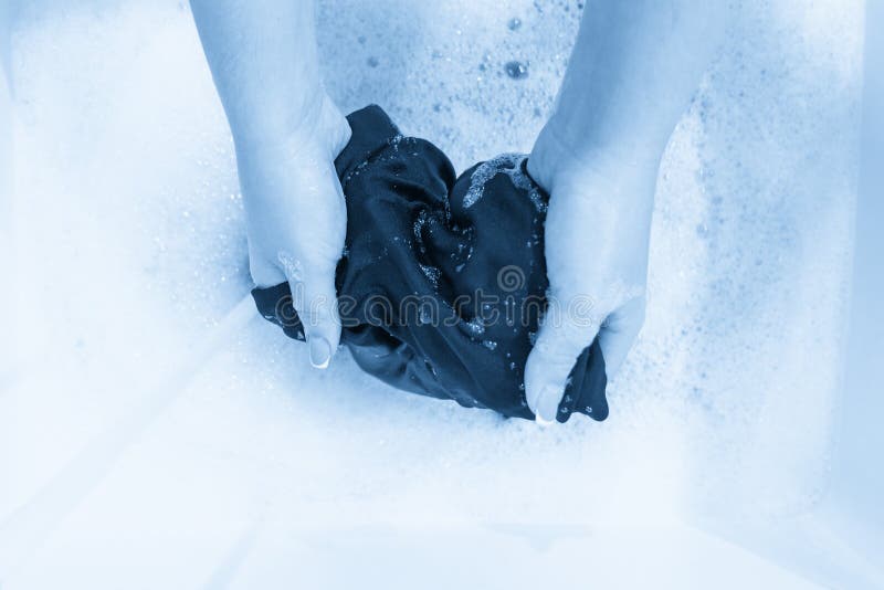 Female Hands Washing Black Color Silk Clothes in Basin Stock Photo