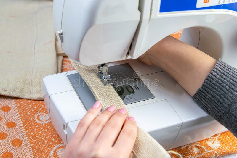 Female hands work on a sewing machine, sewing coffee towel. Close-up