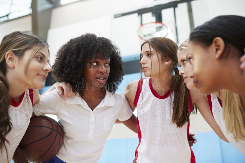Female High School Basketball Players In Huddle Having Team Talk With Coach royalty free stock photography Female High School Basketball Players In Huddle Having Team Talk With Coach royalty free stock photography