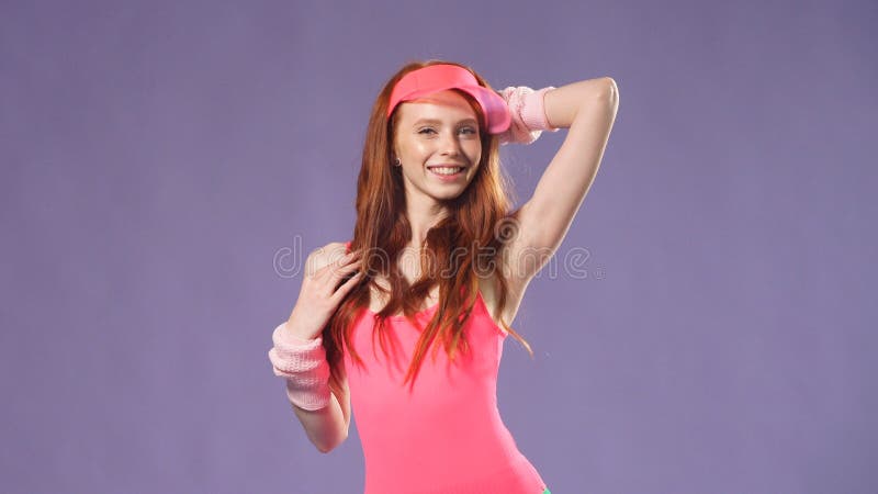 Female instructor in a pink bodysuit and green leggings retro 80s looking at the camera royalty free stock images Female instructor in a pink bodysuit and green leggings retro 80s looking at the camera royalty free stock images