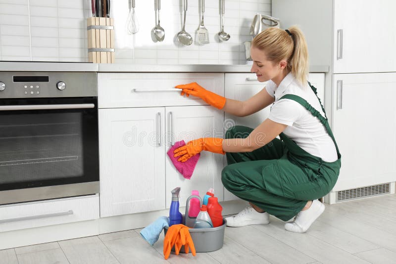 Female janitor cleaning cabinet with rag royalty free stock photo Female janitor cleaning cabinet with rag royalty free stock photo