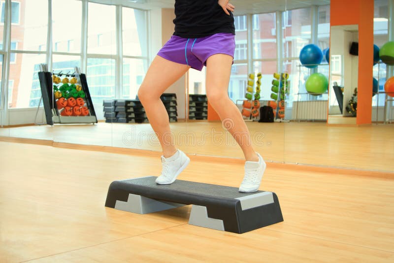 Female legs on the step board during exercise