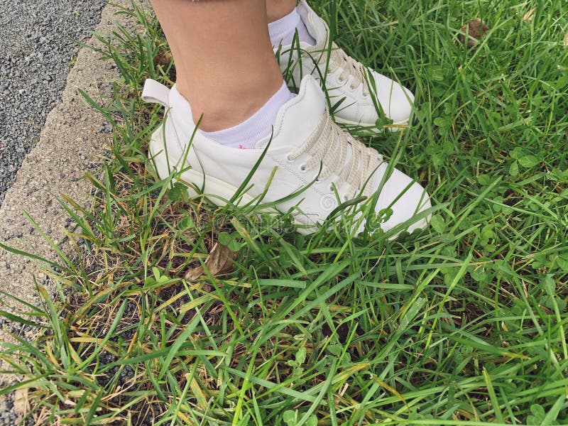 Female Legs in Whote Leather Sneakers Standing on a Grass in Park ...