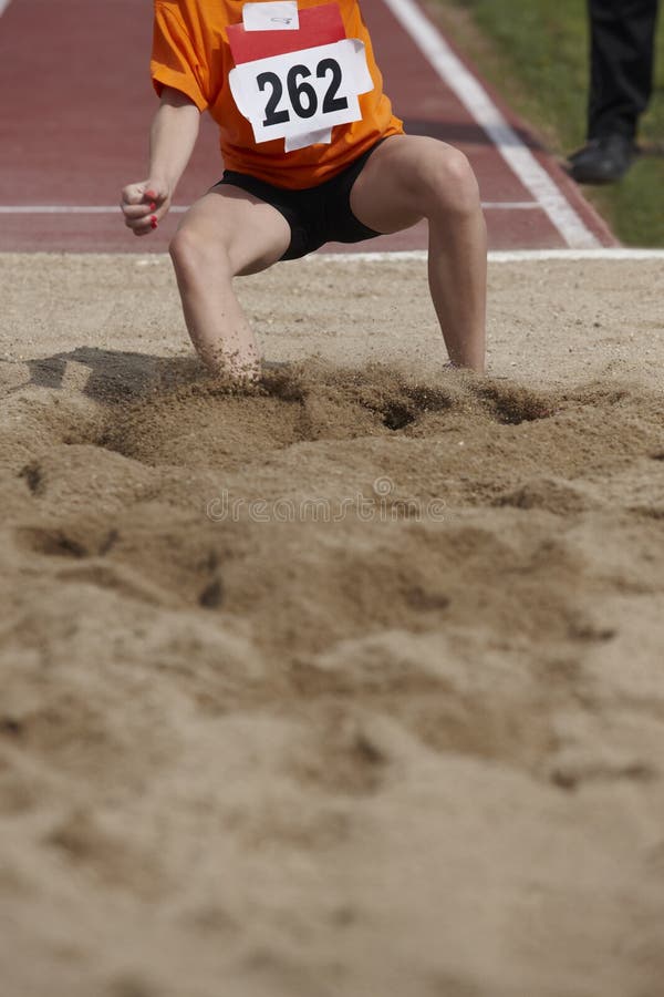 Female Long Jump Competition with Woman Fallin in the Sand Editorial