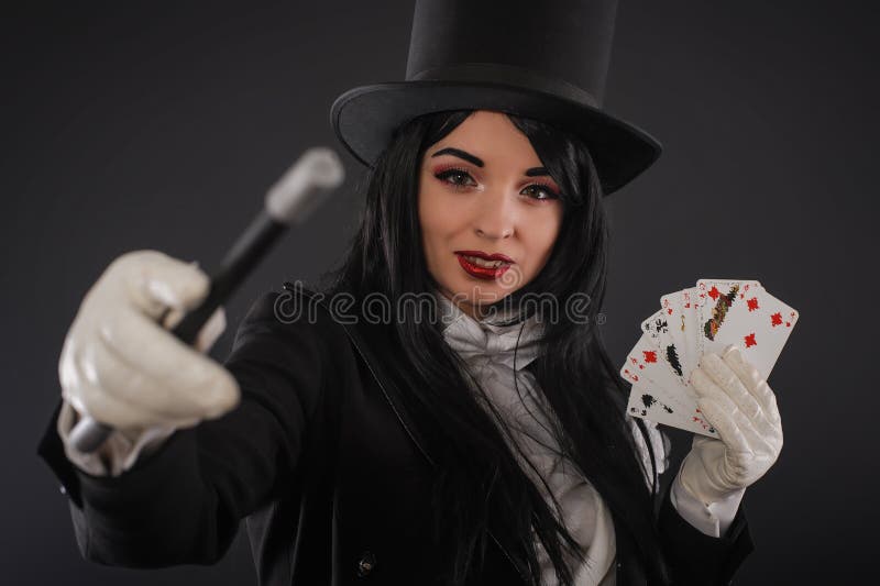 Female magician in performer suit with magic wand and playing ca royalty fr...