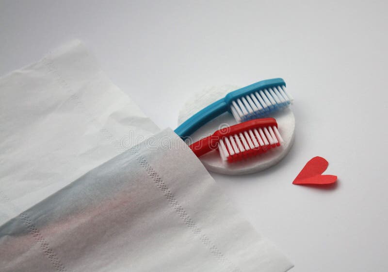 Female and male toothbrushes hugging in bed, visual metaphore of love royalty free stock photography Female and male toothbrushes hugging in bed, visual metaphore of love royalty free stock photography