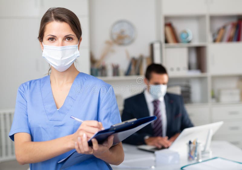 Female Medical Worker Meeting Staff in Office, Monitoring Health Status