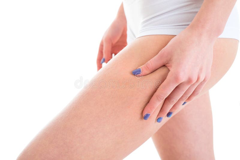 Female model checking cellulite on her legs. Woman Isolated over