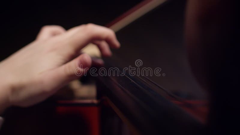 Female musician plays classical music on cello, fingering the strings, closeup. Woman plays stringed musical instrument stock video