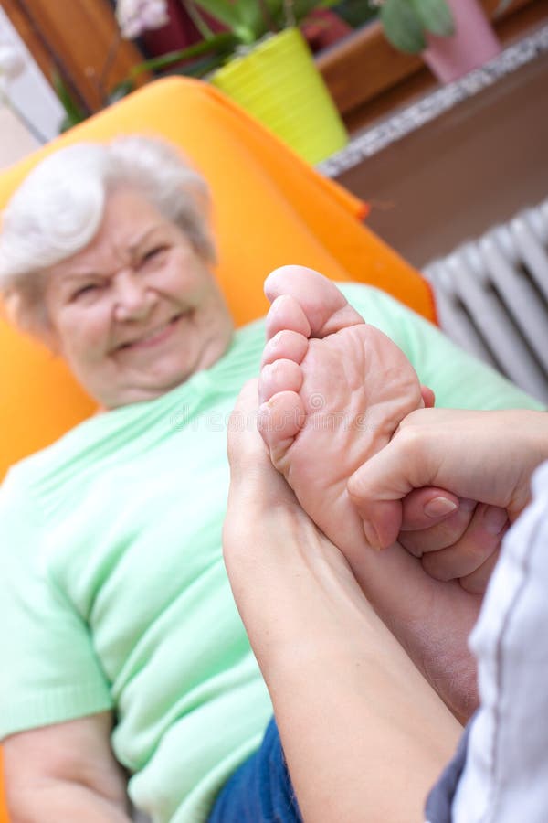 Female Nurse massaging foot of an elderly woman. Female Nurse massaging foot of an elderly woman