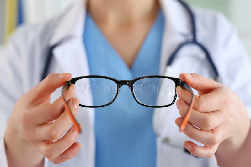 Female oculist doctor hands giving pair of glasses. Good vision stock photography Female oculist doctor hands giving pair of glasses. Good vision stock photography