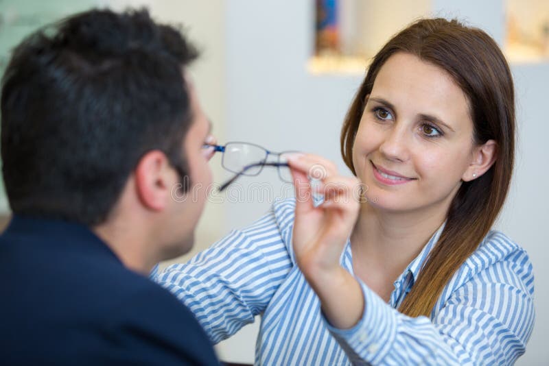 Female Optician Fitting Eyeglasses To Male Client Stock Image Image