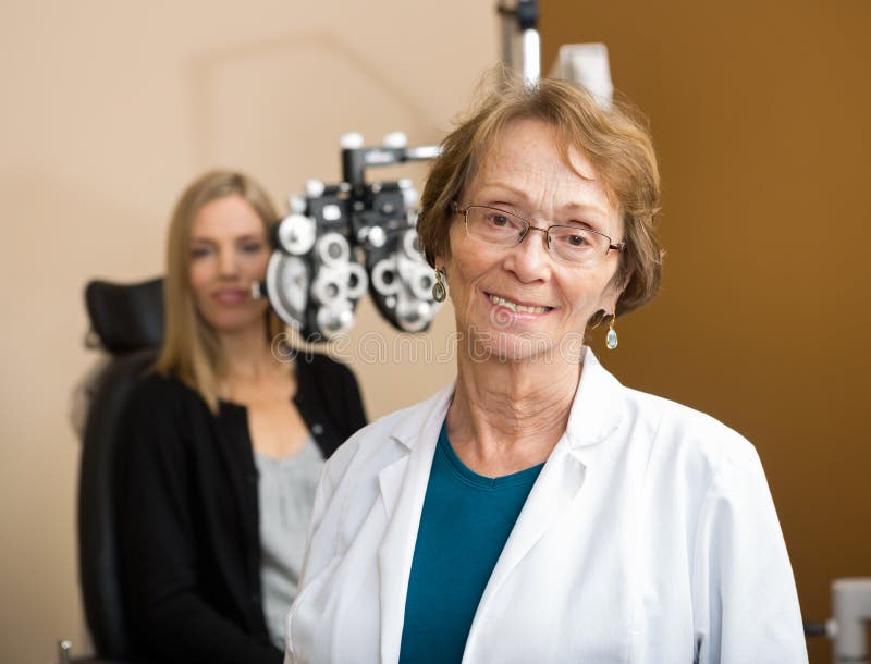 Female Optometrist with Patient in Background Stock Photo Image of