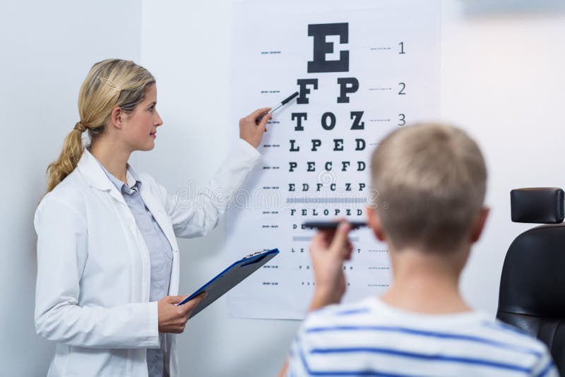 Female optometrist taking eye test of young patient stock photos Female optometrist taking eye test of young patient stock photos