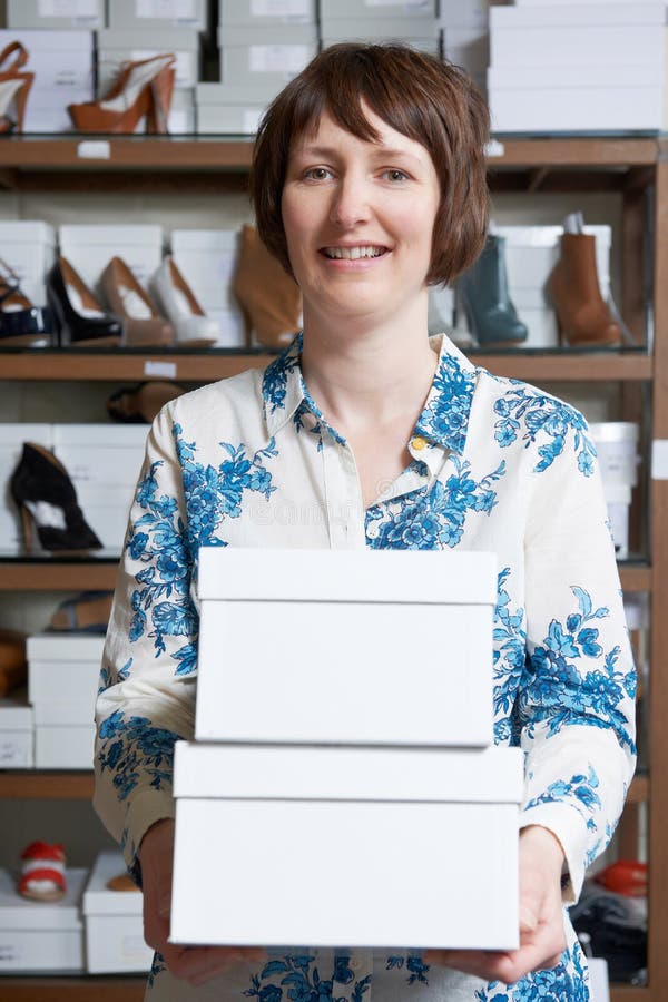 Female Owner Of Shoe Store Carrying Boxes royalty free stock photography Female Owner Of Shoe Store Carrying Boxes royalty free stock photography