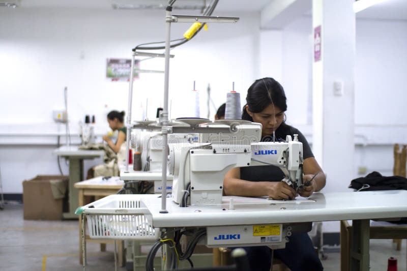 Female Peruvian worker with sewing machine making alterations to clothes. stock image Female Peruvian worker with sewing machine making alterations to clothes. stock image