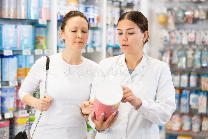 Woman Pharmacist Helping Woman Customer Choose Baby Formula in Pharmacy ...
