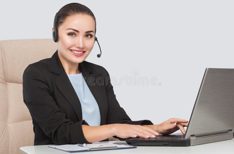 Female phone operator is smiling and and talks on the phone. Helpline answering. Work in the office. Call Center Service.