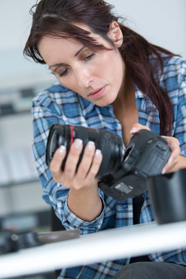 Female photographer holding professional camera - isolated over white royalty free stock photography Female photographer holding professional camera - isolated over white royalty free stock photography
