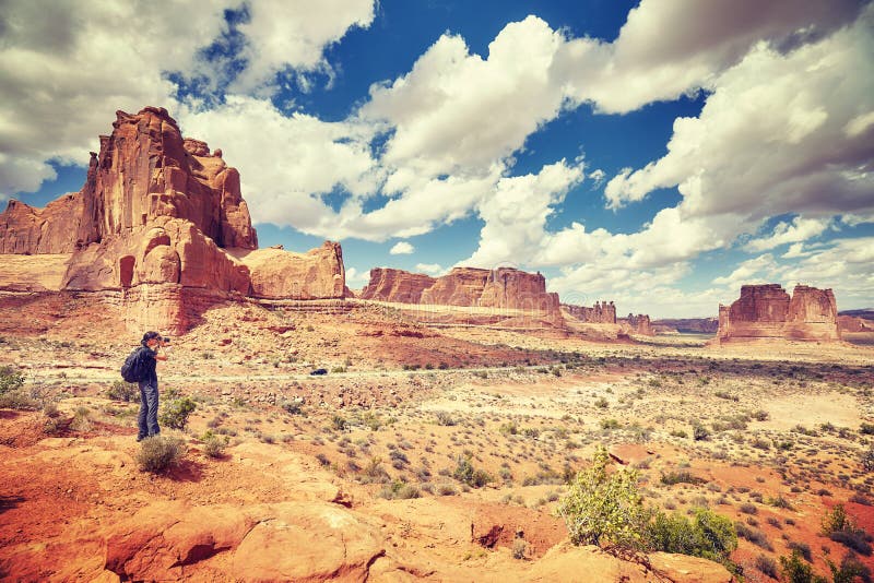 Female photographer takes pictures in Arches National Park.