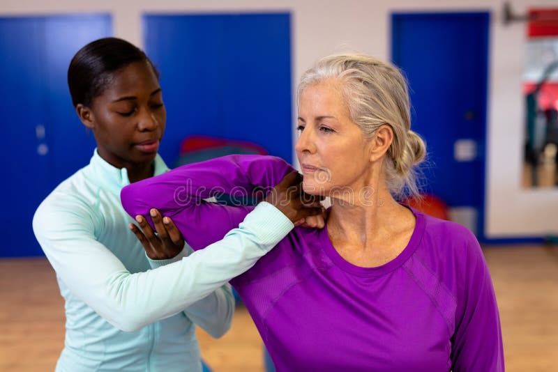 Female Physiotherapist Giving Arm Massage To Active Senior Woman In