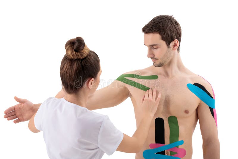 Female physiotherapist putting on kinesio tape on patient& x27;s shoulder royalty free stock images
