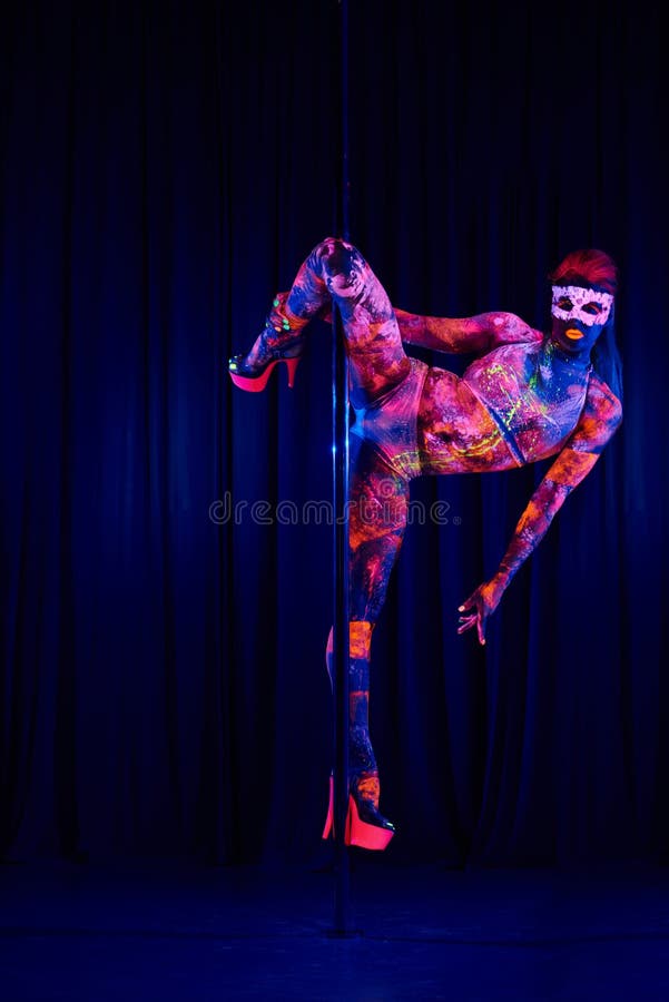 Female Pole Dancer in Bright Neon Colours Under Ultraviolet Stock Photo