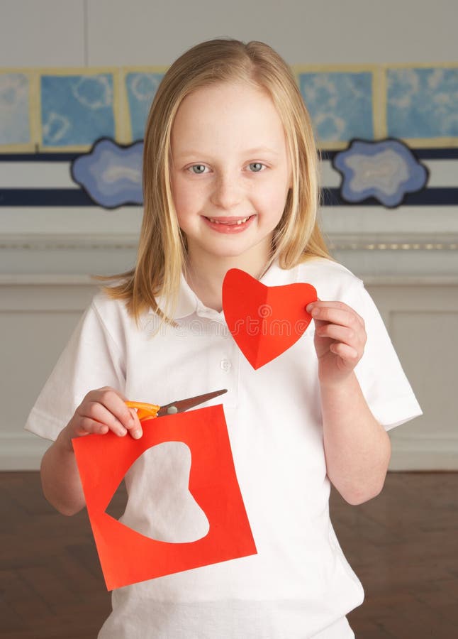 Female Primary School Pupil Cutting Out Shapes stock photography Female Primary School Pupil Cutting Out Shapes stock photography