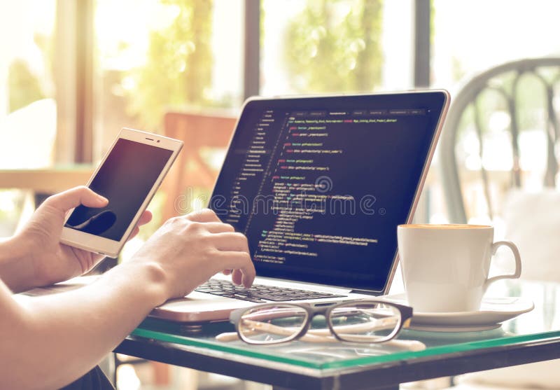 A female programmer typing source codes and using mobile phone in a coffee shop with a relaxing working environment. Studying, Working, Technology, Freelance Work, Web Design Business, and Web Development Concept. Source code script stock images, royalty-free photos and pictures