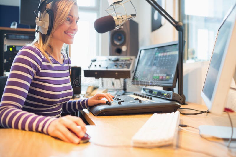 Female radio host using computer while broadcasting stock image Female radio host using computer while broadcasting stock image