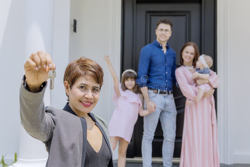 Female realtor showing keys with her customers